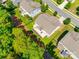 Aerial view of a backyard featuring lush green grass, mature trees, and a cozy patio area at 14727 Brannock Hills Dr, Charlotte, NC 28278