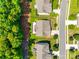 Aerial view of a backyard featuring lush green grass, mature trees, and a cozy patio area at 14727 Brannock Hills Dr, Charlotte, NC 28278