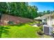 Spacious backyard featuring lush green grass, mature trees, and a cozy patio area at 14727 Brannock Hills Dr, Charlotte, NC 28278