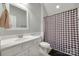 Well-lit bathroom with a clean white vanity, toilet, and shower featuring a checkered shower curtain at 14727 Brannock Hills Dr, Charlotte, NC 28278