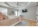 Bright bedroom with a ceiling fan, dresser, TV, and a comfortable chair creating a cozy and inviting space at 14727 Brannock Hills Dr, Charlotte, NC 28278