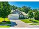 Charming exterior of a home featuring a two-car garage, well-maintained lawn, and a mix of stone and plank exterior accents at 14727 Brannock Hills Dr, Charlotte, NC 28278
