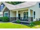 Inviting front porch with stone pillars, seating area, fresh landscaping, and a covered entrance at 14727 Brannock Hills Dr, Charlotte, NC 28278