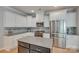 This kitchen features an island, tiled backsplash, stainless steel appliances, and white cabinetry at 14727 Brannock Hills Dr, Charlotte, NC 28278