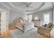 A serene bedroom boasts a tray ceiling, fan, plush furnishings, and bright natural light at 14727 Brannock Hills Dr, Charlotte, NC 28278
