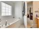 Bathroom featuring tub and fixtures, with a view to the main bedroom at 1583 Cold Creek Pl, Huntersville, NC 28078