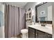 Well-lit bathroom offers a vanity with dark cabinets, a shower with a curtain, and organized storage at 1583 Cold Creek Pl, Huntersville, NC 28078