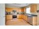 Well-equipped kitchen featuring stainless steel appliances, natural wood cabinetry, and a laminate floor at 1583 Cold Creek Pl, Huntersville, NC 28078