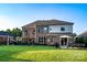 Spacious backyard featuring a brick home, lush lawn, patio and outdoor dining area at 159 Holly Ridge Dr, Mooresville, NC 28115