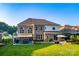Expansive backyard featuring a brick home, lush lawn, patio and outdoor dining area at 159 Holly Ridge Dr, Mooresville, NC 28115