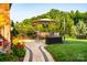 Lush backyard featuring a stone walkway, patio with outdoor dining, and shady trees at 159 Holly Ridge Dr, Mooresville, NC 28115