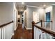 Well-lit hallway showcasing hardwood floors, access to laundry room and bedrooms at 159 Holly Ridge Dr, Mooresville, NC 28115