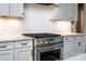 Gourmet kitchen with a professional-grade stainless steel gas range and custom white cabinetry at 159 Holly Ridge Dr, Mooresville, NC 28115