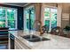 Kitchen island with a stainless steel sink, white cabinets and view to the adjacent dining space at 159 Holly Ridge Dr, Mooresville, NC 28115