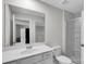 This bathroom features a white vanity with double sinks, a large mirror, and a glass-enclosed shower at 16404 Wavenly House Dr, Charlotte, NC 28273