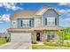Charming two-story home featuring blue and gray siding, stone accents, and a well-manicured front yard at 16404 Wavenly House Dr, Charlotte, NC 28273