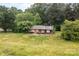 Aerial view of a cozy brick house with mature trees surrounding the property at 168 Pleasant Creek Dr, Cleveland, NC 27013