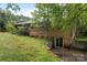 Back exterior view of a brick house featuring a walkout basement and wooded surroundings at 168 Pleasant Creek Dr, Cleveland, NC 27013