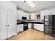 Well-lit kitchen features stainless steel appliances, white cabinets, and a warm, wood-look floor at 18137 Amberwood Glen Dr, Cornelius, NC 28031