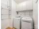 Efficient laundry room with front loading washer and dryer and white storage cabinets at 18137 Amberwood Glen Dr, Cornelius, NC 28031