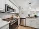 Well-lit kitchen featuring stainless steel appliances, white cabinetry, and stone countertops at 18817 Nautical Dr # 302, Cornelius, NC 28031