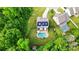 Aerial view showcases a beautiful home with a pool and solar panels, surrounded by lush greenery at 1970 Topaz Plz, Davidson, NC 28036
