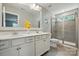 Well-lit bathroom with dual sinks, granite counters, and a glass-enclosed shower at 1970 Topaz Plz, Davidson, NC 28036