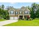 Home with brick, stone, and siding details, plus three-car garage and well-manicured lawn at 1970 Topaz Plz, Davidson, NC 28036