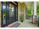 Inviting front porch with a black front door, sidelights, and brick accents at 1970 Topaz Plz, Davidson, NC 28036