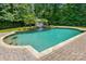 Backyard swimming pool with waterfall feature, landscaping, and hardscaped patio at 1970 Topaz Plz, Davidson, NC 28036