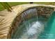 Close up of a custom waterfall feature with stone accents in the backyard swimming pool at 1970 Topaz Plz, Davidson, NC 28036