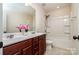 Bathroom features a granite-topped double vanity, large mirror, tub and shower combination at 203 Rustling Waters Dr, Mooresville, NC 28117