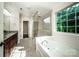 Luxurious bathroom featuring a soaking tub, glass shower, and elegant fixtures at 203 Rustling Waters Dr, Mooresville, NC 28117