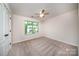 Bedroom features neutral carpet, ceiling fan, and a window providing natural light at 203 Rustling Waters Dr, Mooresville, NC 28117