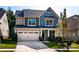 Charming two-story home with a well-manicured lawn, inviting curb appeal, and a two car garage at 203 Rustling Waters Dr, Mooresville, NC 28117