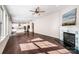 Spacious living room featuring hardwood floors, a fireplace, open concept kitchen, and modern ceiling fan at 203 Rustling Waters Dr, Mooresville, NC 28117