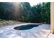 Small in-ground pool with a concrete surround situated within a rock bed in a private backyard at 203 Rustling Waters Dr, Mooresville, NC 28117