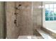Modern tiled shower with built in seat, handheld shower head and decorative accent tiling at 203 Rustling Waters Dr, Mooresville, NC 28117