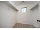 Carpeted walk-in closet with adjustable shelving and a window for natural light at 203 Rustling Waters Dr, Mooresville, NC 28117