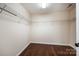Empty walk-in closet with a hardwood floor and white walls and shelving at 203 Rustling Waters Dr, Mooresville, NC 28117