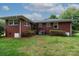 Exterior rear view of a red brick home with a grassy yard and greenery at 205 Hillcrest Ave, Rock Hill, SC 29732