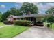 An attractive brick home featuring a carport, screened-in porch, and lush greenery at 205 Hillcrest Ave, Rock Hill, SC 29732