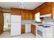 Eat-in kitchen boasts white appliances and wood cabinetry at 205 Hillcrest Ave, Rock Hill, SC 29732