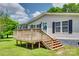 Exterior angle view of the home showcasing its wooden deck, black shutters, and manicured lawn at 284 Cedar Grove Rd, Clover, SC 29710