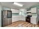 Well-lit kitchen featuring white cabinetry, modern stainless steel refrigerator, and black oven range at 284 Cedar Grove Rd, Clover, SC 29710