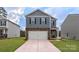Charming two-story home with stone accents, gray siding, a two-car garage and a well-manicured lawn at 3090 Ora Smith Rd, Lincolnton, NC 28092