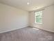 An empty bedroom with neutral carpet and a window providing natural light at 323 J C Dellinger Rd, Cherryville, NC 28021