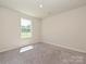 Empty bedroom with neutral carpet, bright window, and freshly painted walls at 323 J C Dellinger Rd, Cherryville, NC 28021