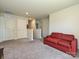 Cozy bonus room with neutral carpet, a comfortable red sofa, and ample space for entertainment at 323 J C Dellinger Rd, Cherryville, NC 28021