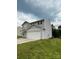 Side view of a gray two-story home featuring a two-car garage and green lawn at 323 J C Dellinger Rd, Cherryville, NC 28021